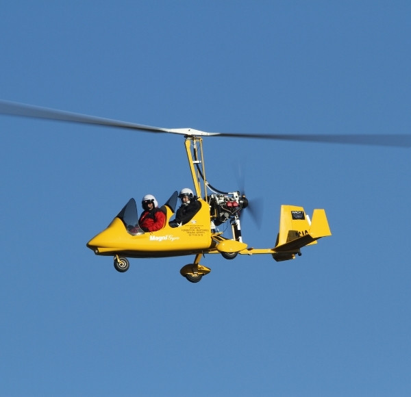 yellow gyrocopter on blue sky