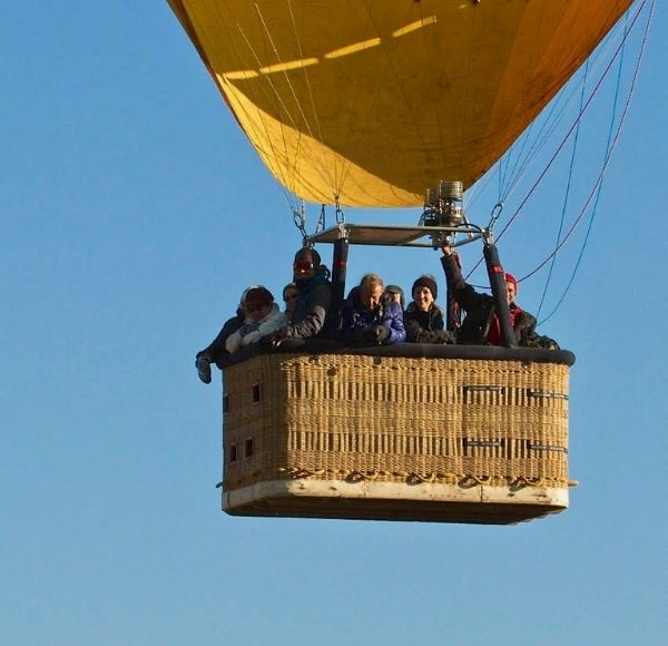Family in a blue sky balloon basket