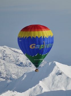 Vol en montgolfière au dessus des montagnes enneigées