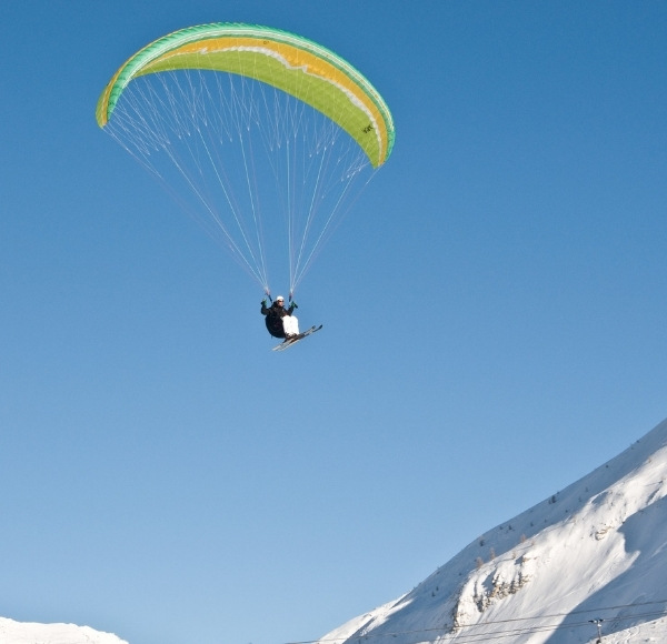 Winter paragliding flight with skis